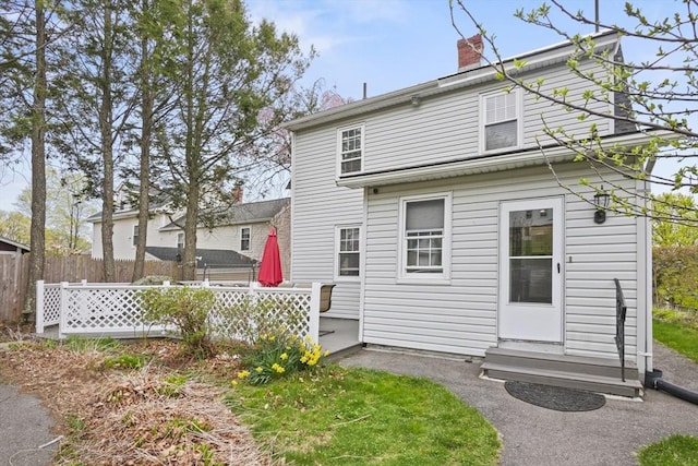 21 Vernon St, Lowell, MA 01850 - back of property featuring fence, a chimney, and entry steps