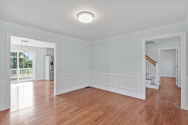 empty room with ornamental molding and hardwood / wood-style flooring