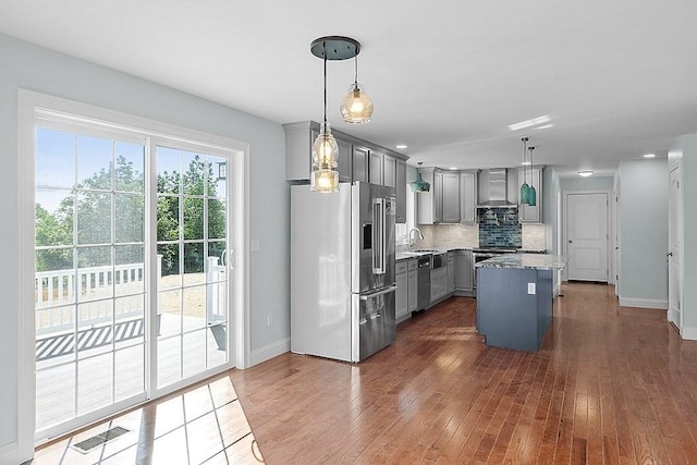 kitchen with decorative light fixtures, a center island, stainless steel appliances, and gray cabinets