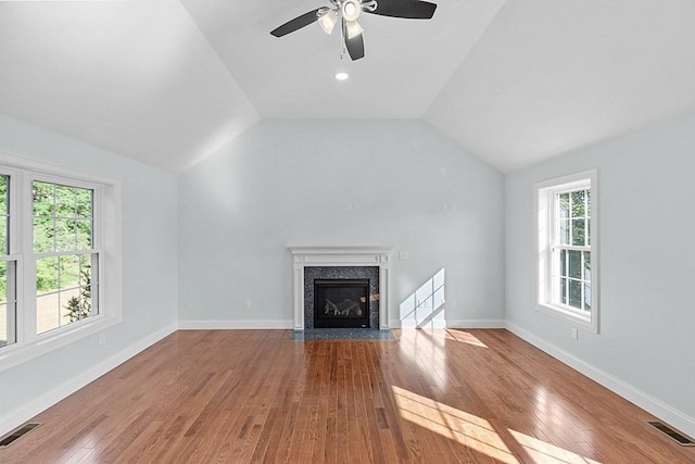 unfurnished living room with a fireplace, light wood-type flooring, ceiling fan, and lofted ceiling