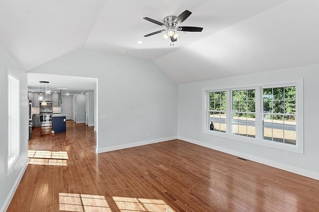 unfurnished living room featuring dark hardwood / wood-style floors, ceiling fan, and vaulted ceiling