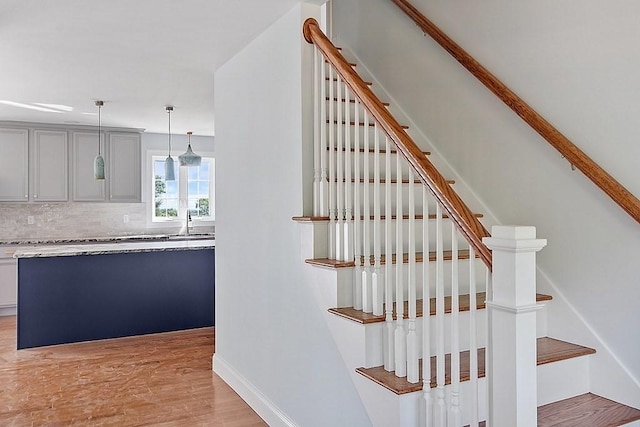 stairway with hardwood / wood-style flooring and sink