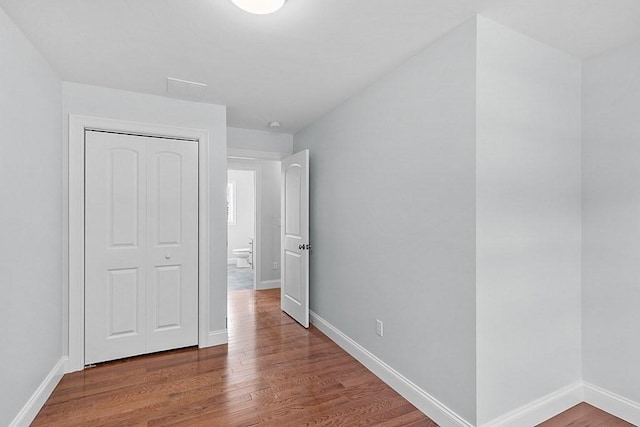 unfurnished bedroom featuring a closet and wood-type flooring