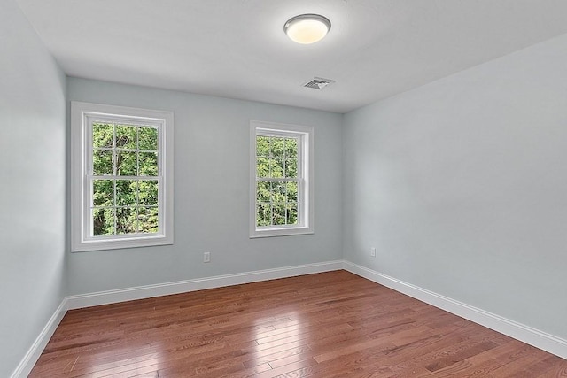 spare room with hardwood / wood-style flooring and plenty of natural light