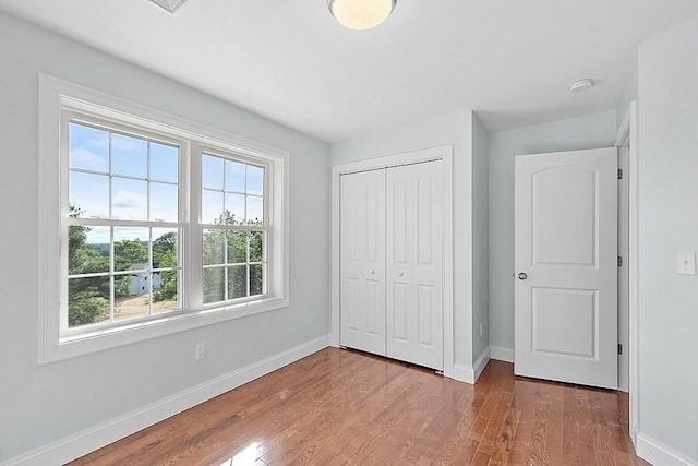 unfurnished bedroom featuring a closet and hardwood / wood-style flooring