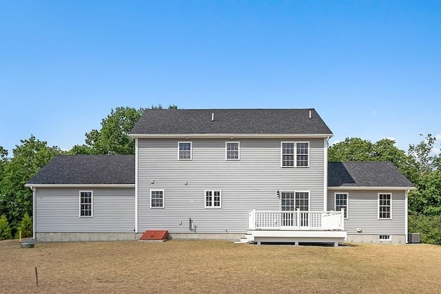 back of house with a lawn, a deck, and central AC