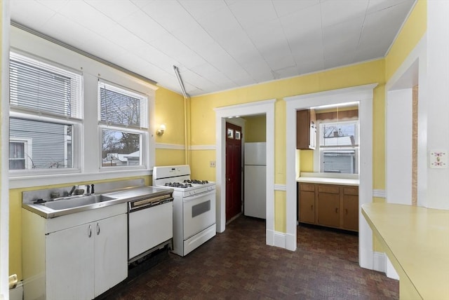 kitchen with light countertops, white appliances, and a sink