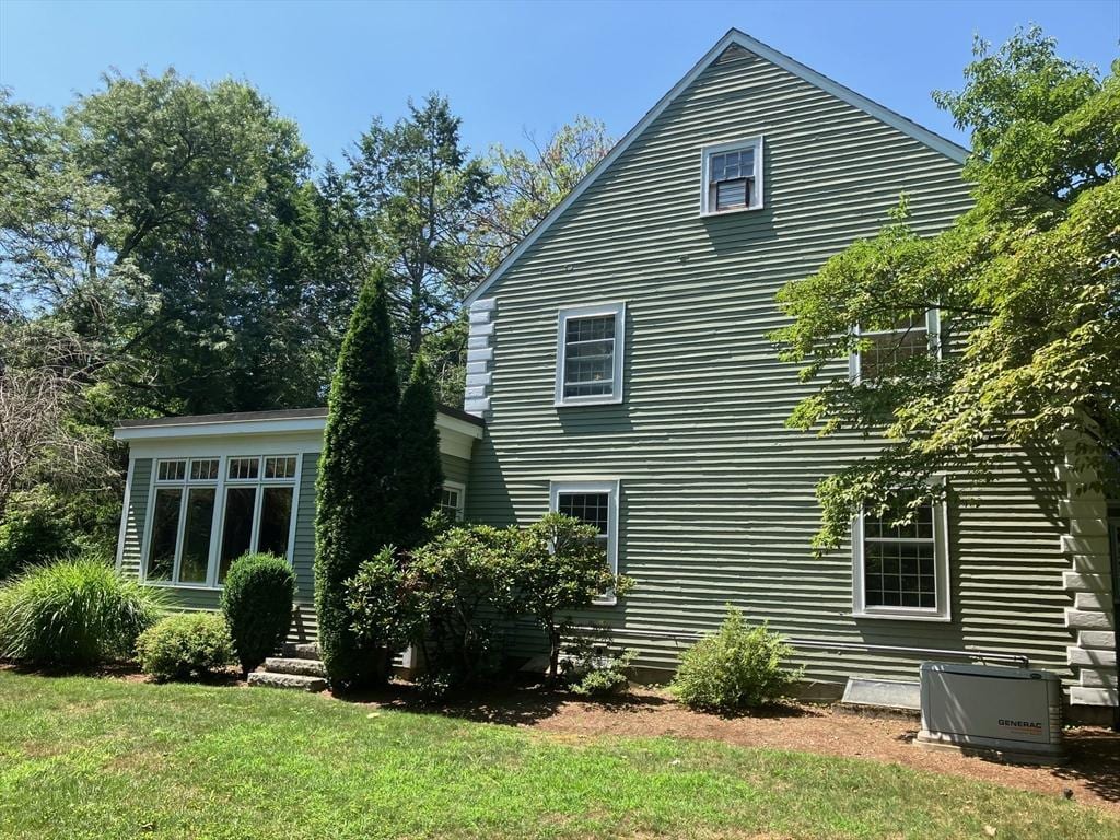 rear view of property with a lawn and central air condition unit