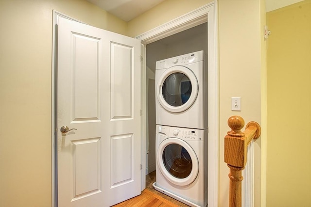 laundry area featuring light wood-type flooring and stacked washer and dryer