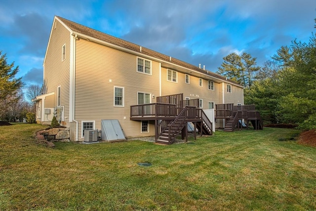 rear view of property featuring a lawn, cooling unit, and a wooden deck