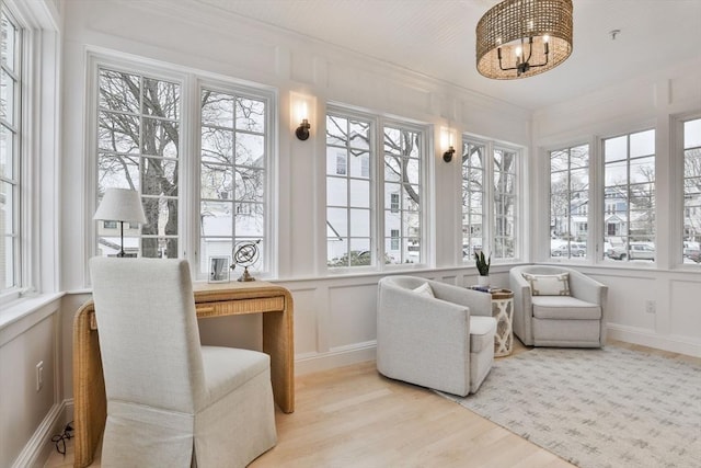 sunroom featuring a chandelier and a healthy amount of sunlight