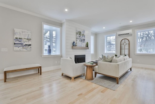 living room featuring a fireplace, light wood-type flooring, a wall unit AC, and crown molding