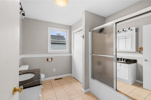 full bathroom featuring tile patterned flooring, vanity, combined bath / shower with glass door, and toilet