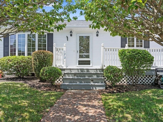 entrance to property featuring a lawn