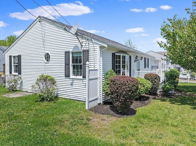 view of side of home with a yard