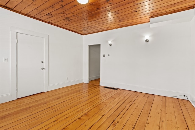 spare room with ornamental molding, light hardwood / wood-style floors, and wooden ceiling