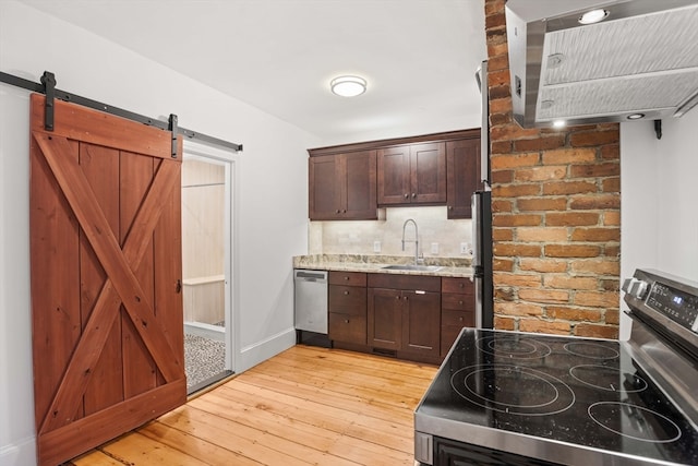 kitchen featuring sink, dark brown cabinets, stainless steel appliances, and light hardwood / wood-style floors