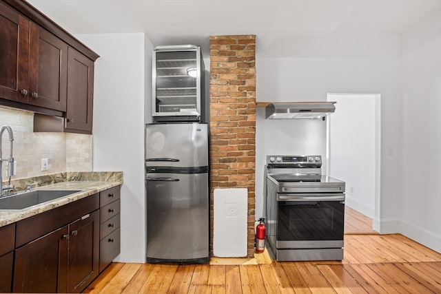 kitchen with sink, light hardwood / wood-style flooring, stainless steel appliances, and extractor fan