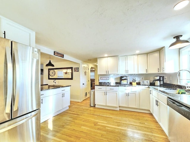 kitchen with white cabinetry, sink, light hardwood / wood-style floors, and appliances with stainless steel finishes