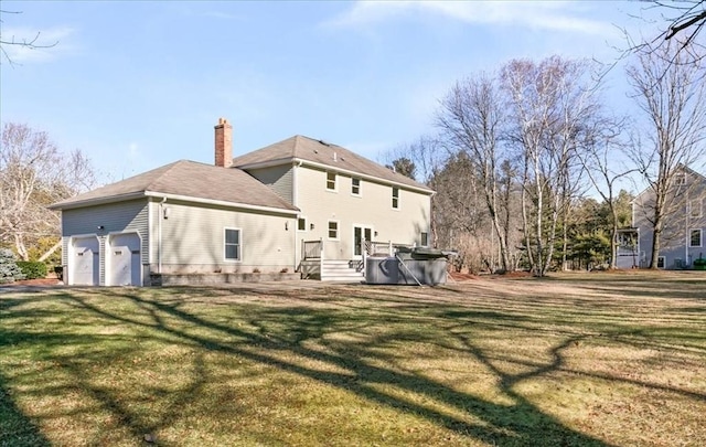 back of property featuring a lawn and a garage