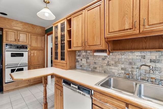 kitchen with a sink, backsplash, white appliances, light countertops, and light tile patterned floors