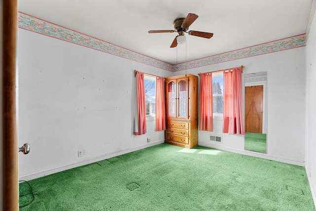 unfurnished bedroom with a ceiling fan, baseboards, visible vents, and carpet floors