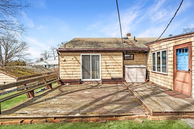 rear view of house featuring a deck and fence