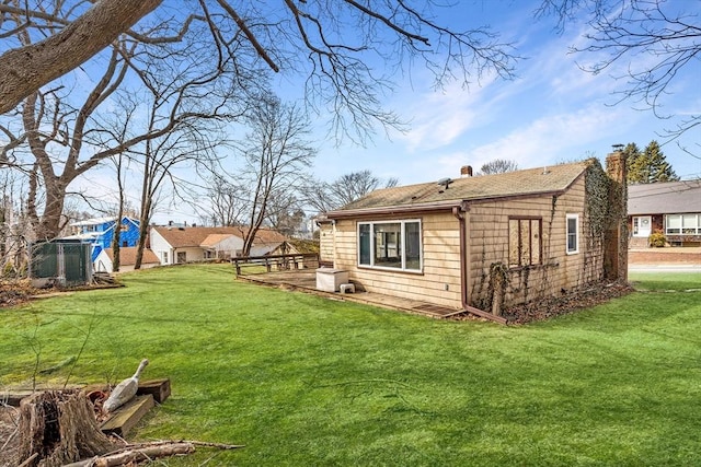 back of property featuring a lawn and roof with shingles