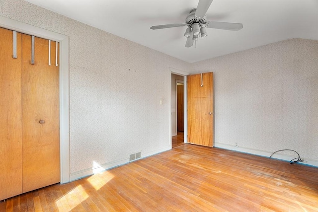 unfurnished bedroom with visible vents, ceiling fan, and hardwood / wood-style flooring