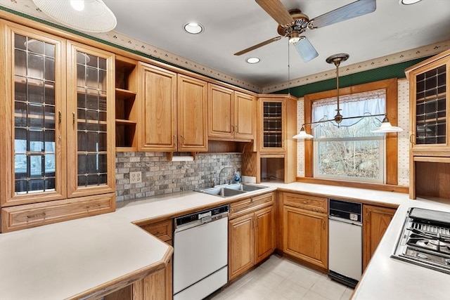 kitchen with stainless steel gas cooktop, a sink, light countertops, glass insert cabinets, and dishwasher