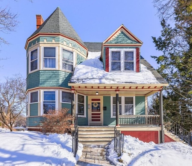 victorian home featuring covered porch, a chimney, and stairs