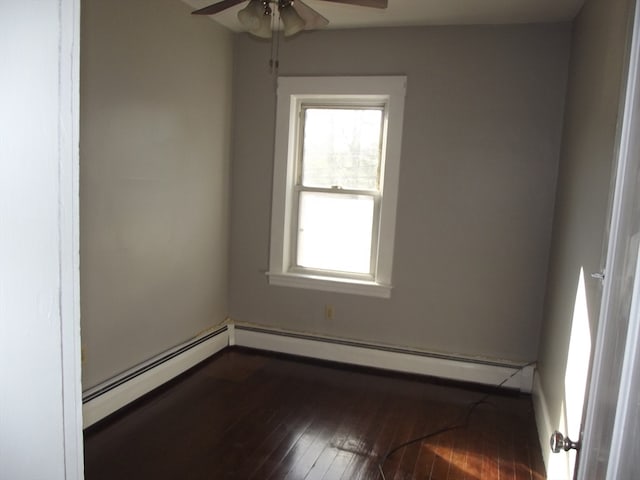 spare room with dark hardwood / wood-style floors, baseboard heating, and ceiling fan