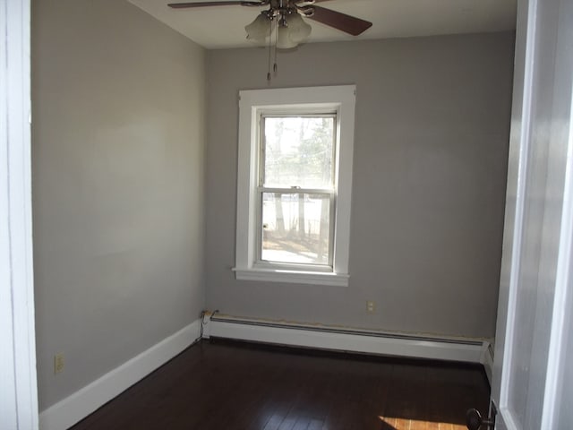 spare room featuring a baseboard radiator, ceiling fan, and dark wood-type flooring