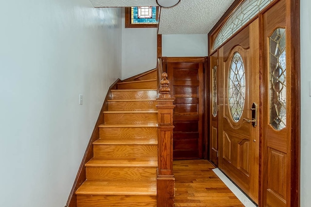 foyer featuring a textured ceiling and light hardwood / wood-style flooring