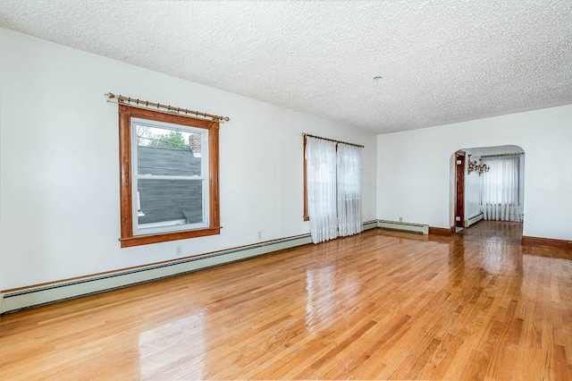 unfurnished room featuring hardwood / wood-style floors, a baseboard radiator, and a textured ceiling