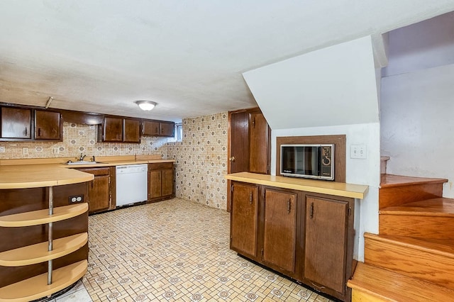 kitchen featuring dishwasher and dark brown cabinets