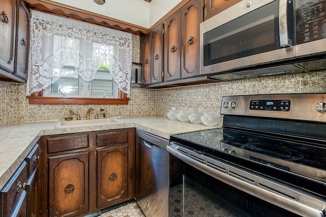 kitchen with light tile patterned floors, stainless steel appliances, tasteful backsplash, and sink