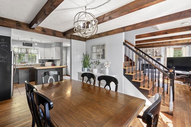 230 W St, Paxton, MA 01612 - dining space featuring light wood-style floors, a chandelier, beam ceiling, and stairs