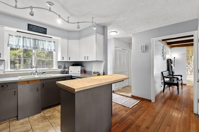 230 W St, Paxton, MA 01612 - kitchen featuring wood counters, a sink, white cabinetry, light wood finished floors, and baseboards