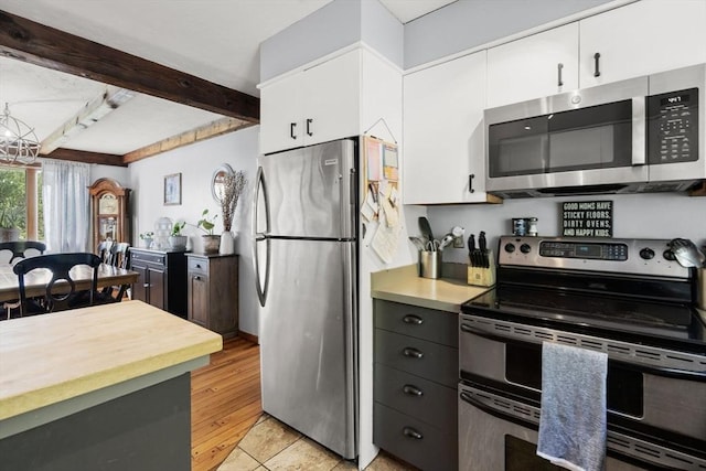 230 W St, Paxton, MA 01612 - kitchen featuring appliances with stainless steel finishes, white cabinetry, beam ceiling, and light tile patterned floors