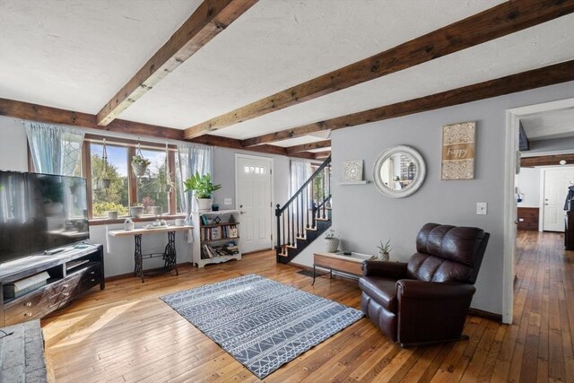 230 W St, Paxton, MA 01612 - living room featuring hardwood / wood-style floors, stairway, beam ceiling, and baseboards