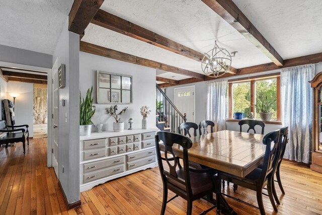 230 W St, Paxton, MA 01612 - dining space featuring stairway, light wood-style flooring, beamed ceiling, and a chandelier