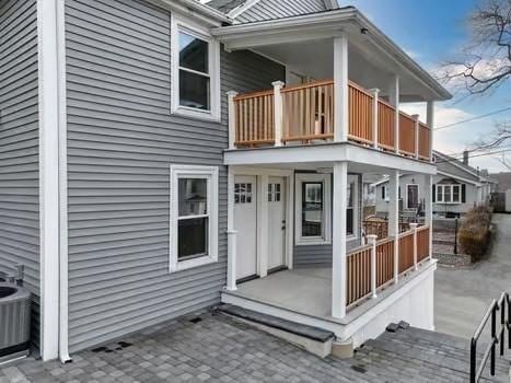 entrance to property with cooling unit and a balcony