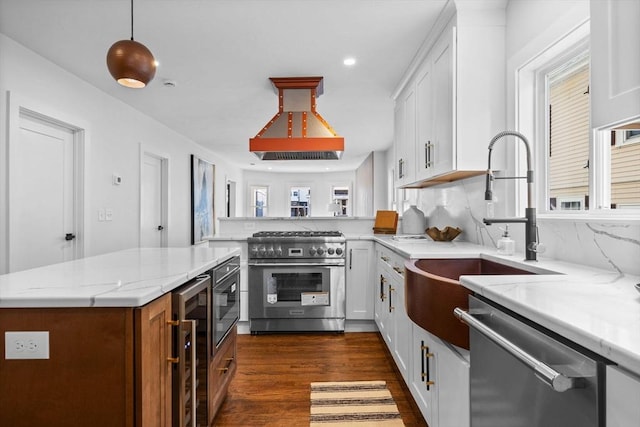 kitchen featuring island exhaust hood, appliances with stainless steel finishes, pendant lighting, and white cabinets