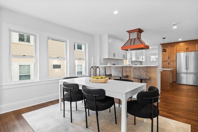 dining space with dark hardwood / wood-style flooring, sink, and a wealth of natural light