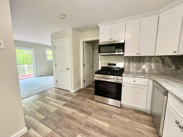 196 Munn Rd, Monson, MA 01057 - kitchen with appliances with stainless steel finishes, white cabinets, tasteful backsplash, light wood-type flooring, and light stone counters