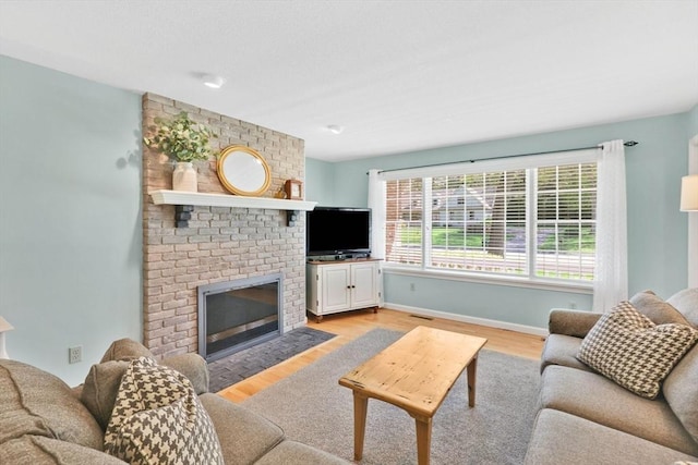 24 Heritage Cir E, Longmeadow, MA 01028 - living area with light wood-style flooring, a brick fireplace, and baseboards