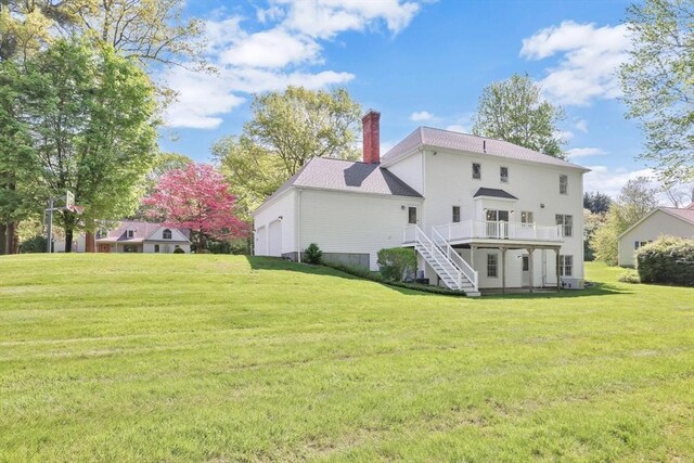 24 Heritage Cir E, Longmeadow, MA 01028 - back of property with stairs, a chimney, a deck, a lawn, and a garage