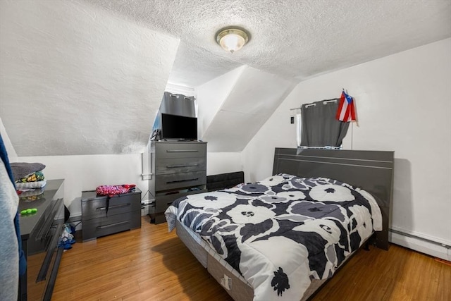 81-83 Walnut St, Lynn, MA 01905 - bedroom with a textured ceiling, wood finished floors, vaulted ceiling, a baseboard heating unit, and baseboards