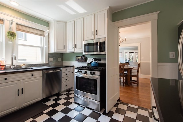 105 Fletcher St Unit 1, Boston, MA 02131 - kitchen with appliances with stainless steel finishes, light floors, dark countertops, a chandelier, and healthy amount of natural light